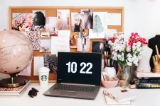 Photo inspirante d'un espace de travail plutôt féminin, beau babillard, plein de photos et fleurs.